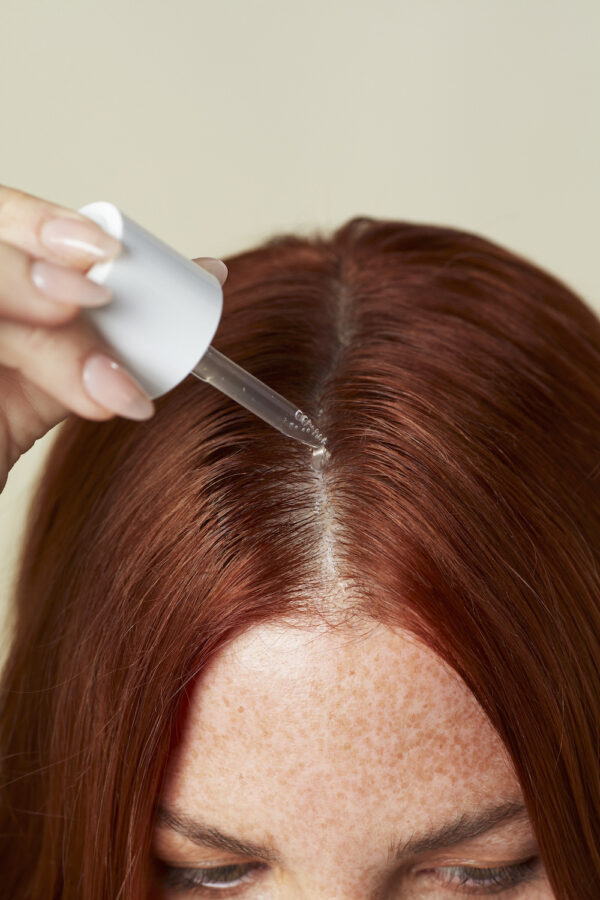 2022_SERUM_SUPPLEMENTS_MODEL_1563-CROPPED OUAI hair care scalp serum application with pipette