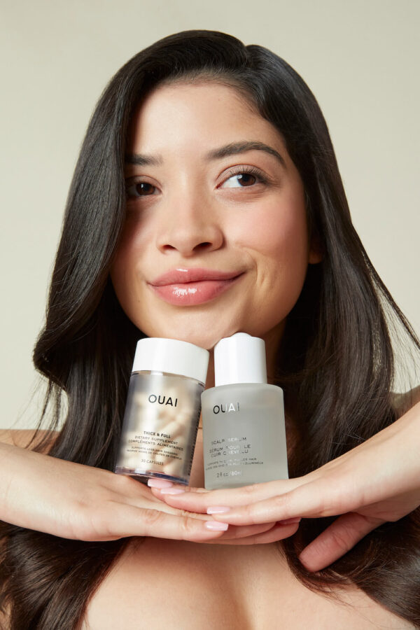 2022_SERUM_SUPPLEMENTS_MODEL_427-CROPPED OUAI hair care scalp serum and thick and full supplements combo set on hands