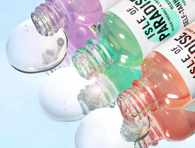 Isle of Paradise Self Tanning Drops in Shade Light, Medium and Dark with product on reflective surface