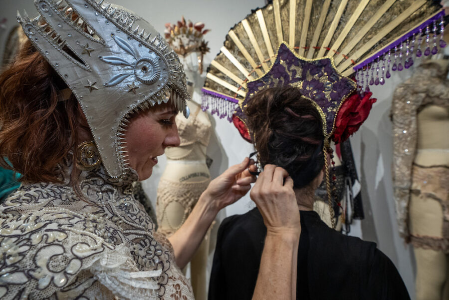 Aviatrix NYC popup Artist Michelle Palmer placing headdress on woman