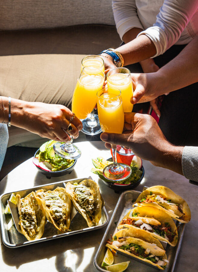 Hands holding mimosas
