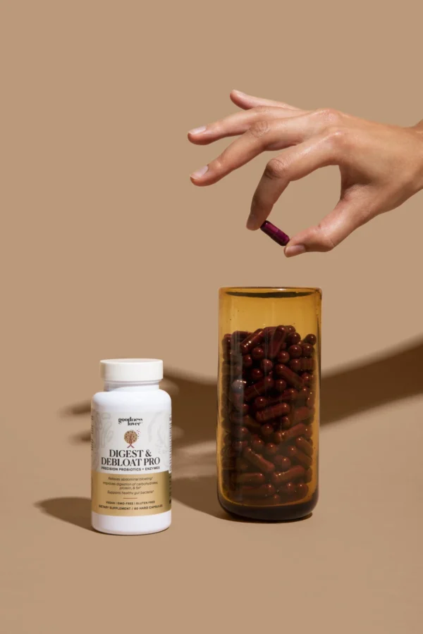 Image of hand holding a capsule from Goodness Lover Digest & Debloat Pro dietary supplement