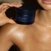 Jar of Olamic Body Butter on top of woman's shoulder