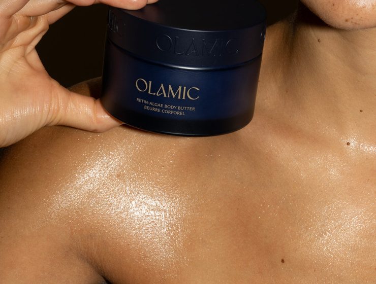 Jar of Olamic Body Butter on top of woman's shoulder