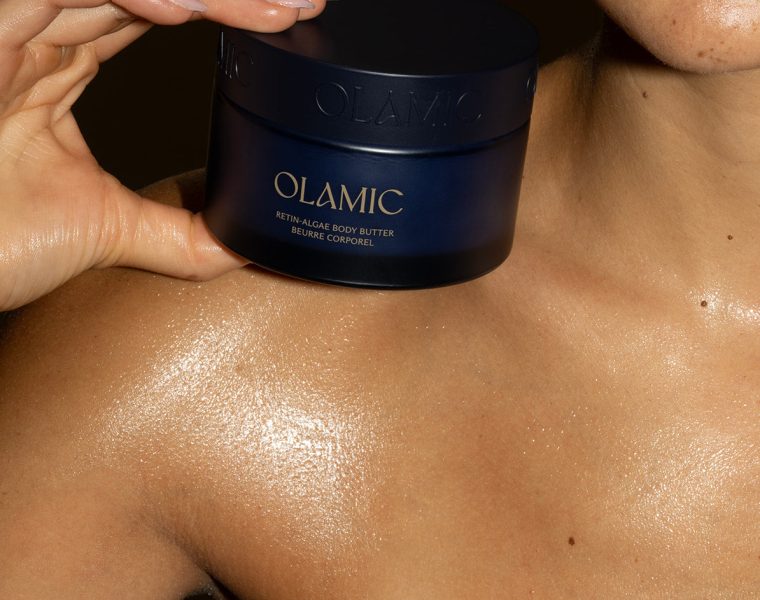 Jar of Olamic Body Butter on top of woman's shoulder