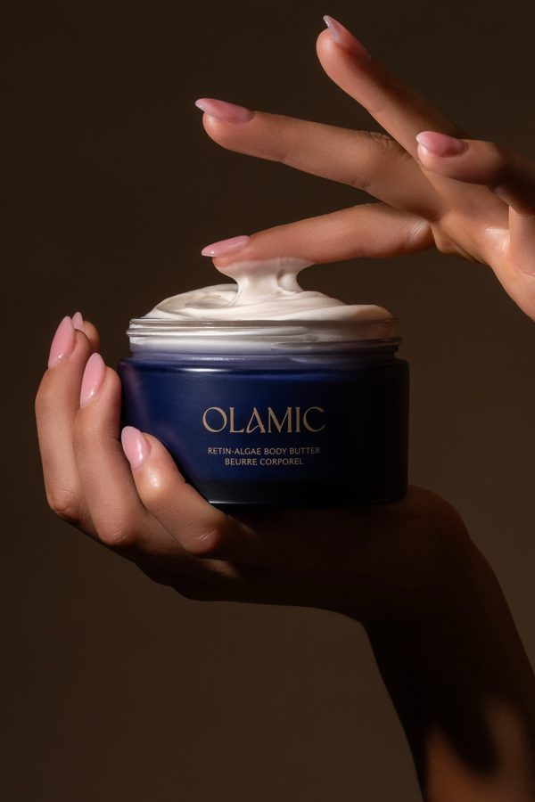 Open jar of Olamic Body Butter and fingers